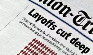 Newspaper with headline about layoffs during COVID-19.
